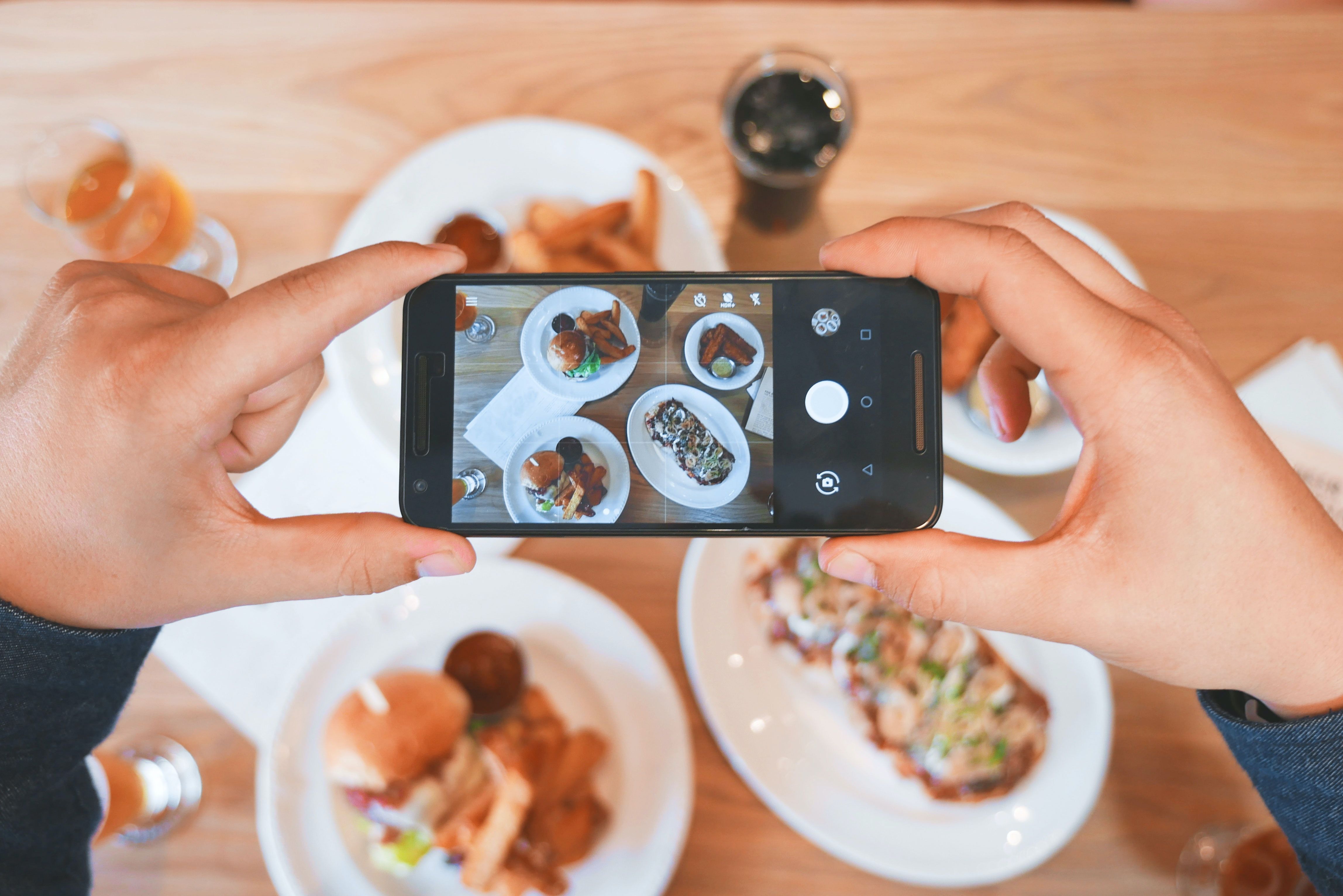 photo of someone taking pictures of food on a smartphone