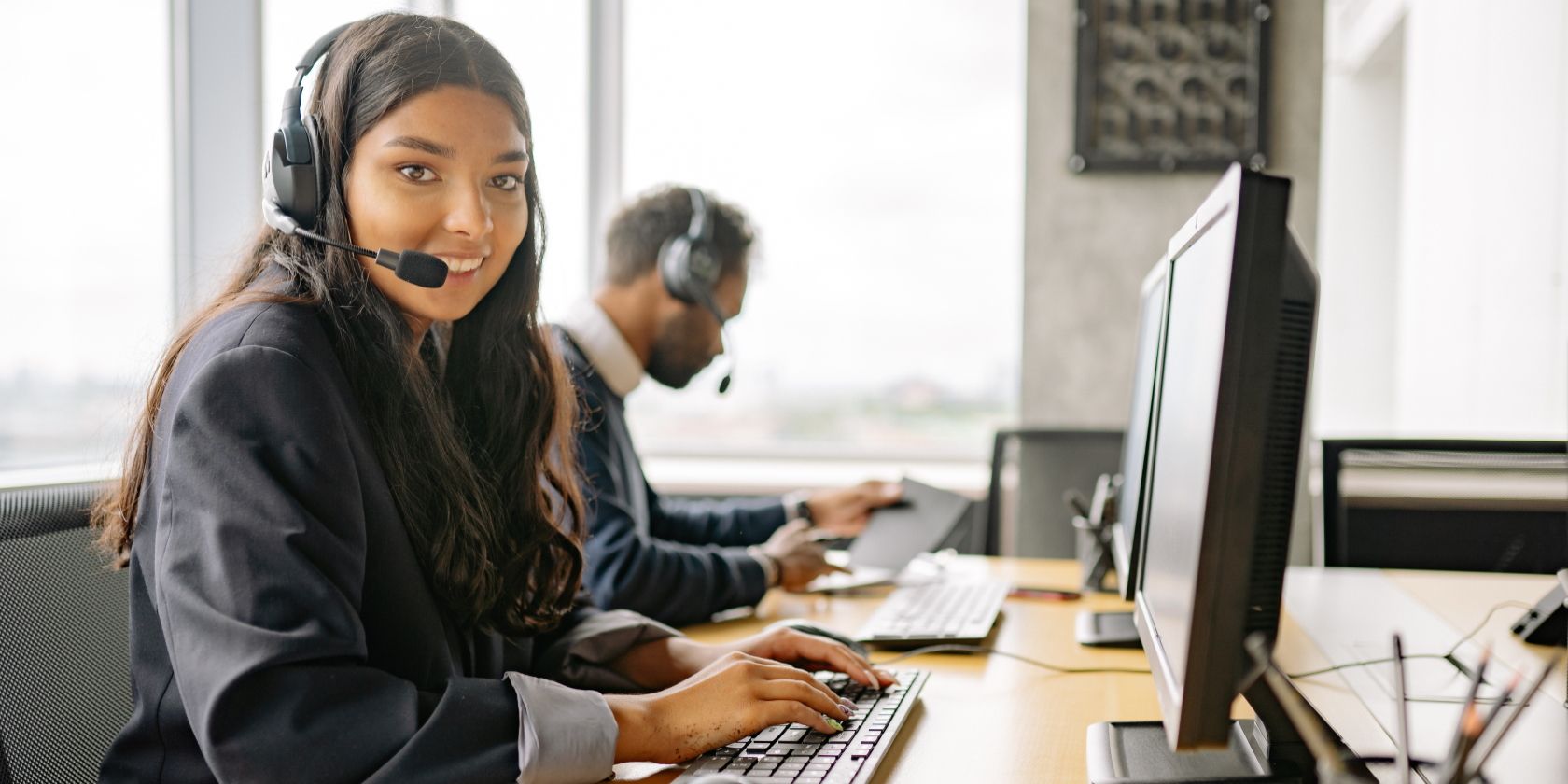 A smiling woman working in a call center.