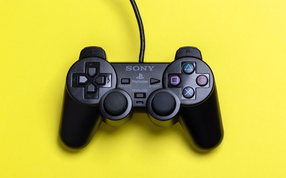 A Sony Playstation controller on a solid yellow background