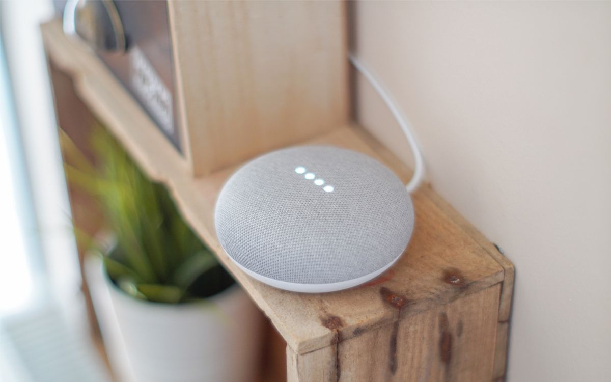 A Google Home speaker on a wooden platform