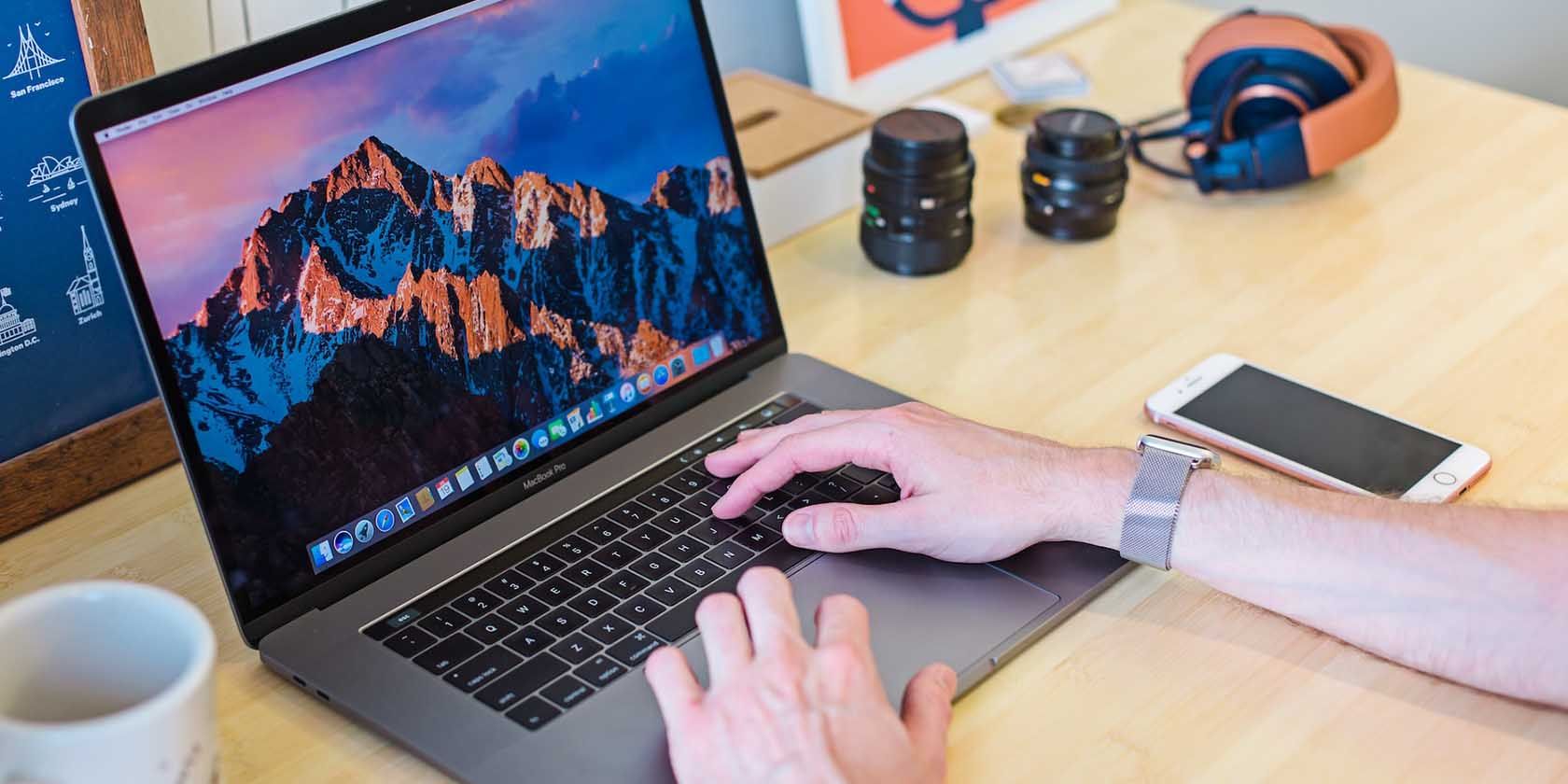Мужчина использует MacBook с ладонями на подставке для ладоней