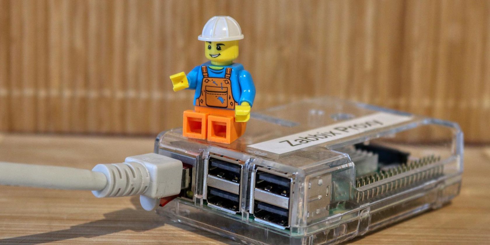 A Raspberry Pi in a case with a LEGO mini figure sitting on top