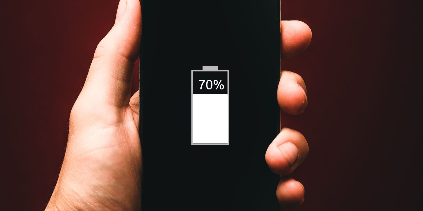 Một bàn tay đang cầm chiếc điện thoại đang hiển thị phần trăm pin 