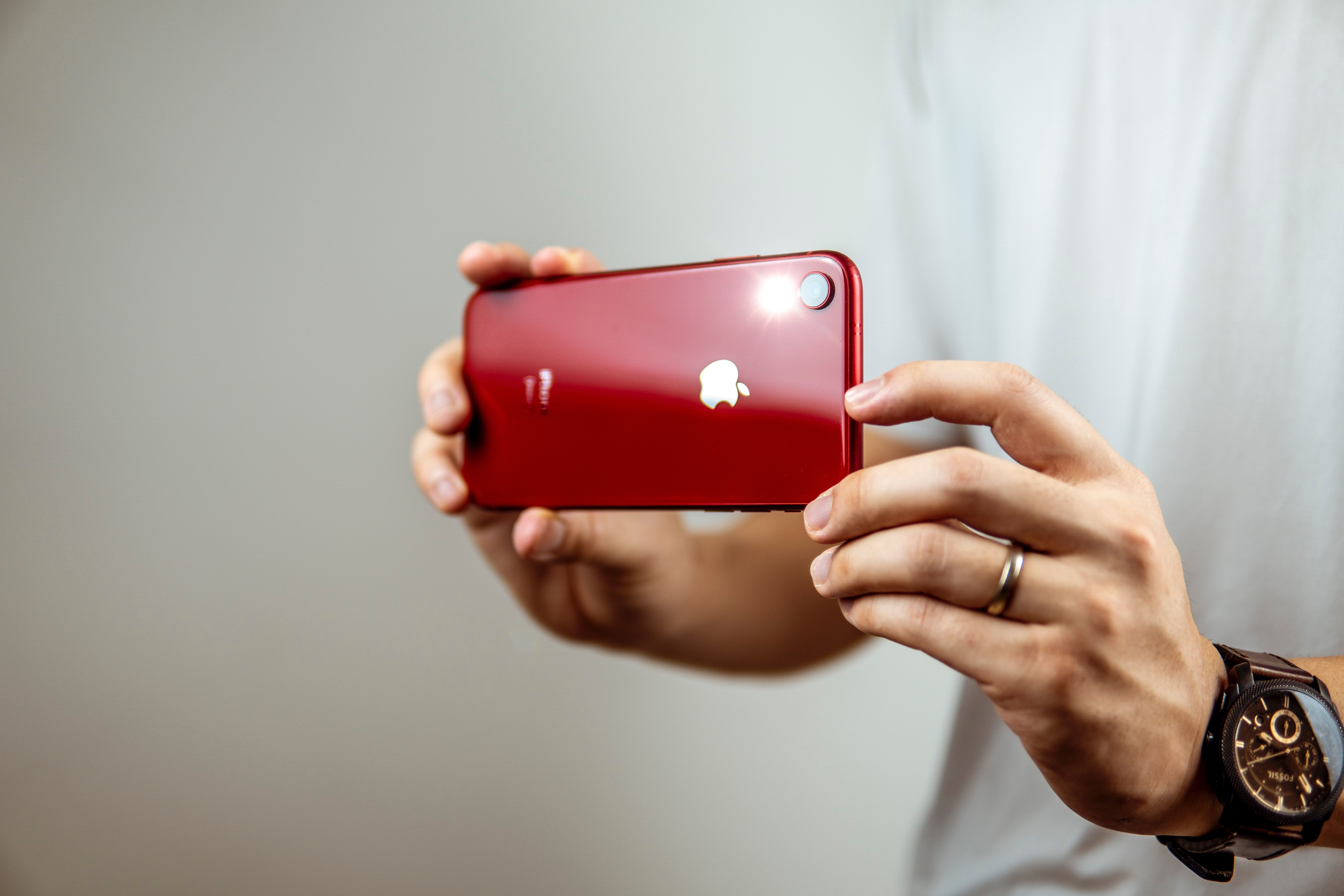 photo of someone taking a picture with a red iphone