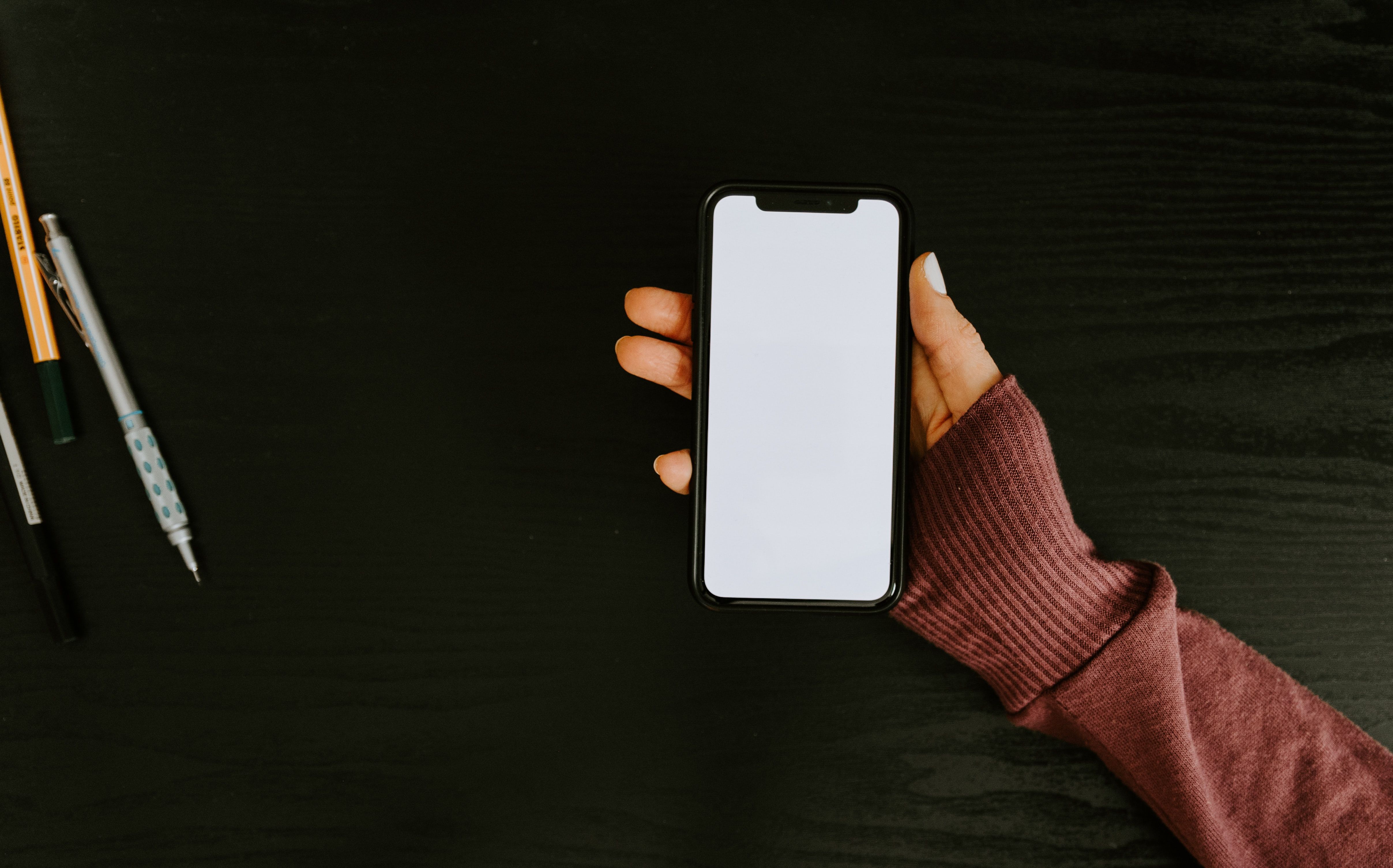 photo of someone holding an iphone with a blank screen