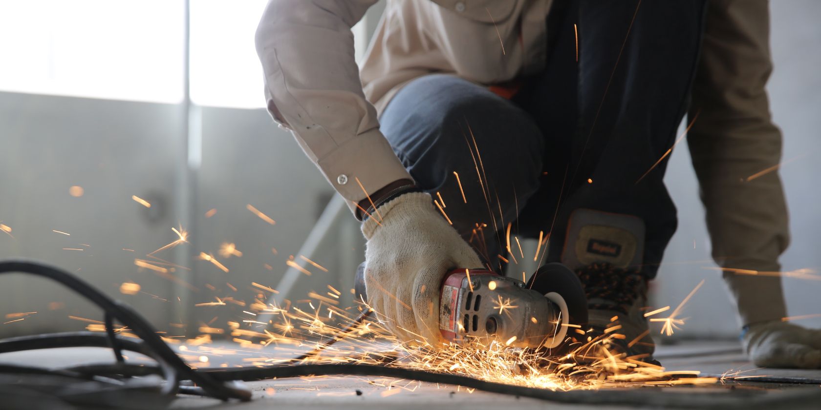 man working on metal with grinder