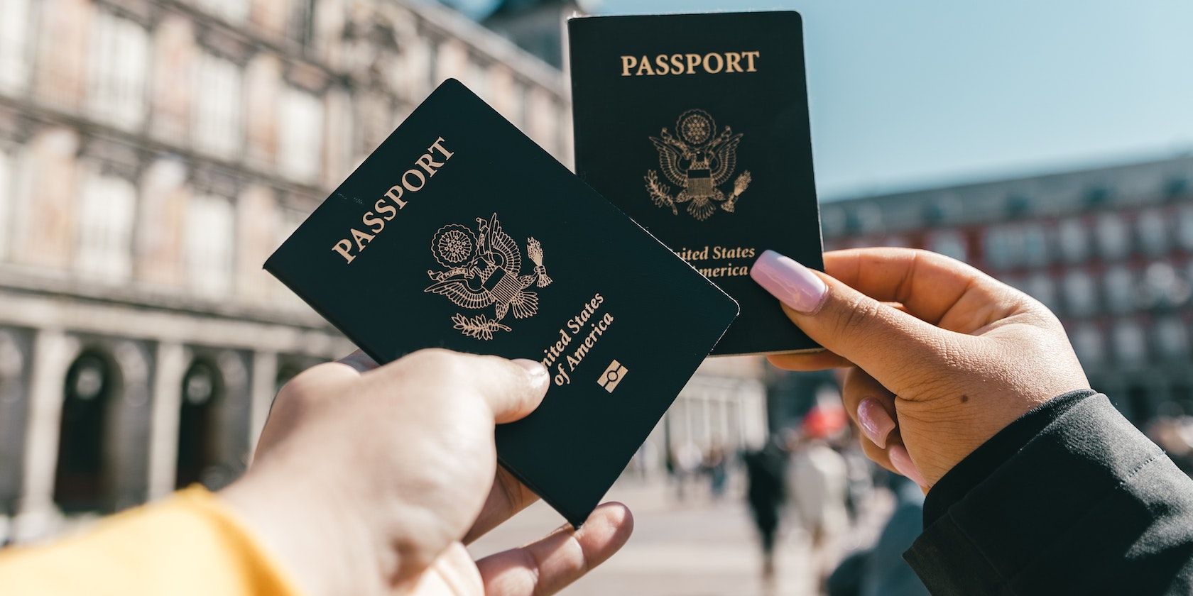 Güneşli bir günde sokakta ABD pasaportlarını gösteren isimsiz turistler