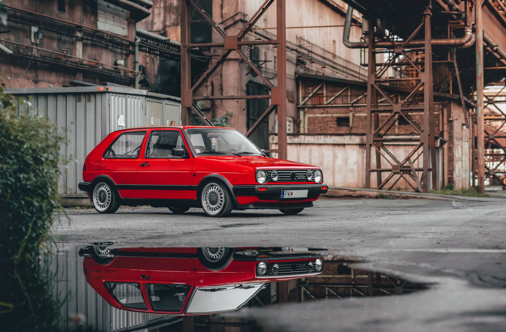 A red wagon shot at a low angle with reflection in a puddle