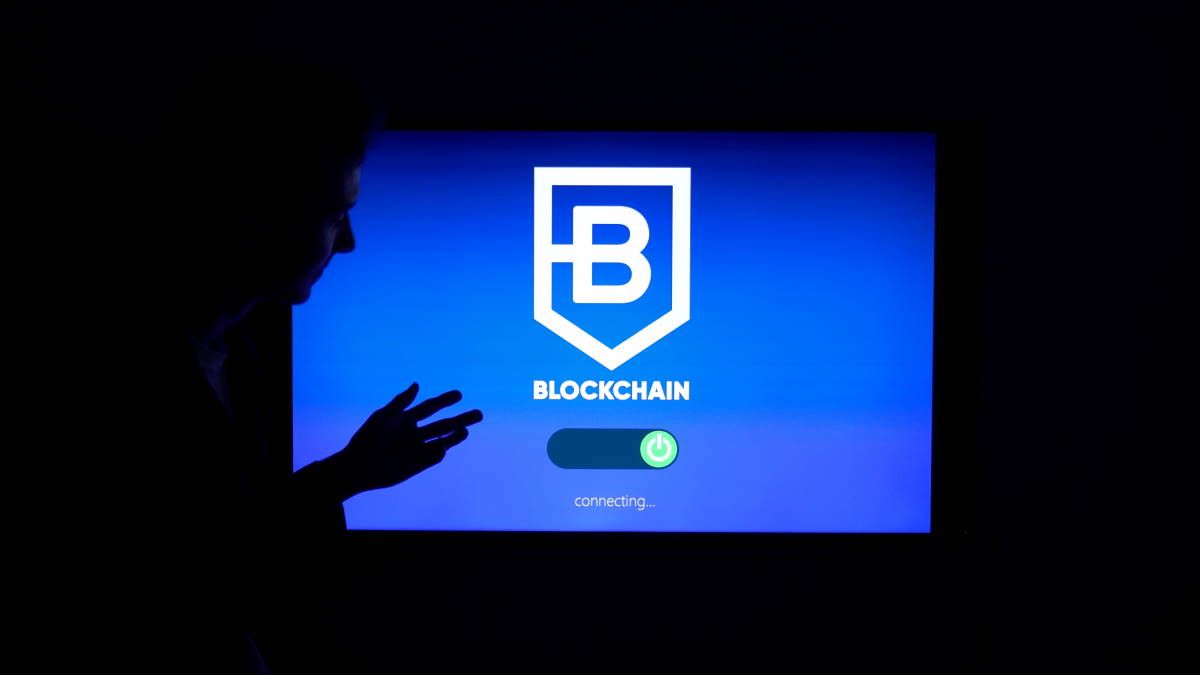 screen-displaying-word-blockchain-man-standing-by
