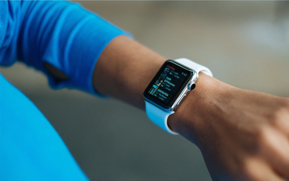 A person wearing an Apple Watch with a white silicone strap