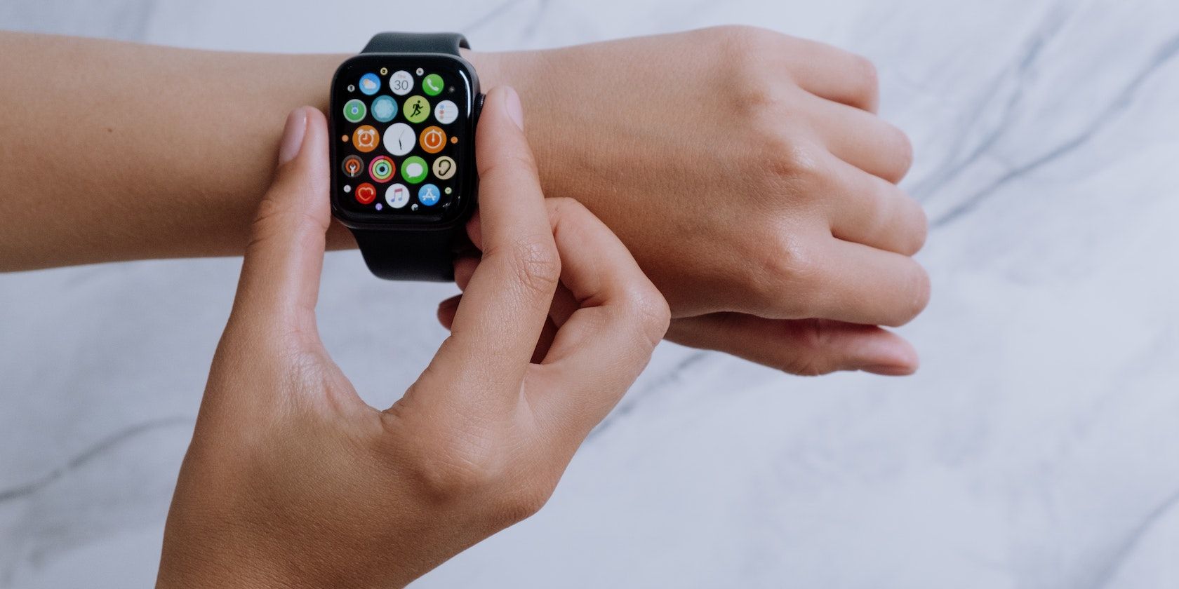Person Wearing Silver Aluminum Case Apple Watch With White Sport Band