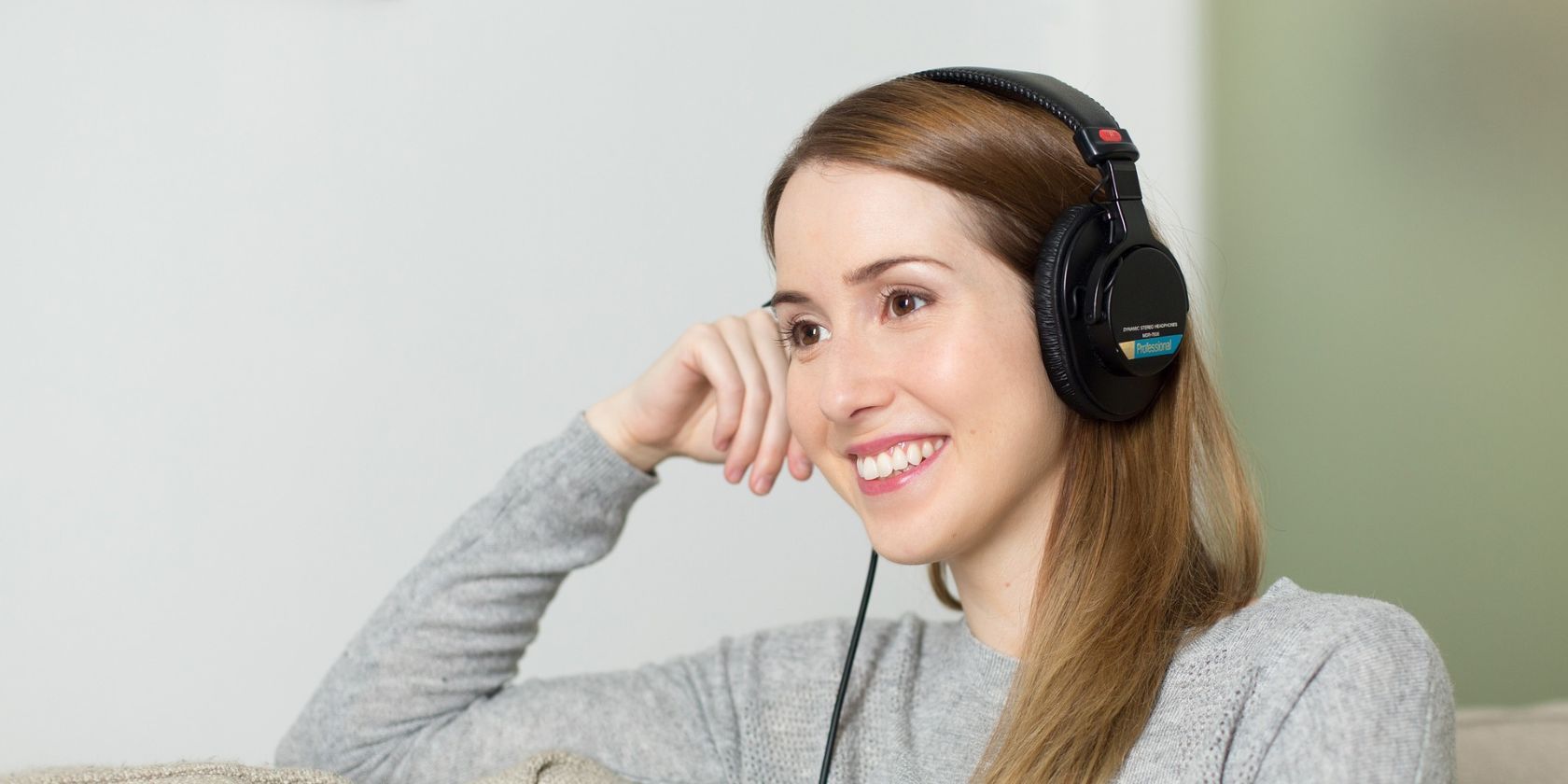 A woman sat down listening to music through her headphones