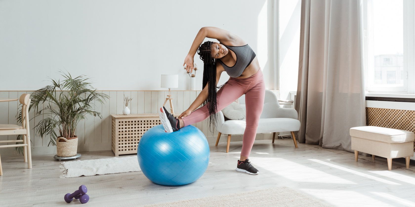 woman using blue exercise ball to stretch her legs