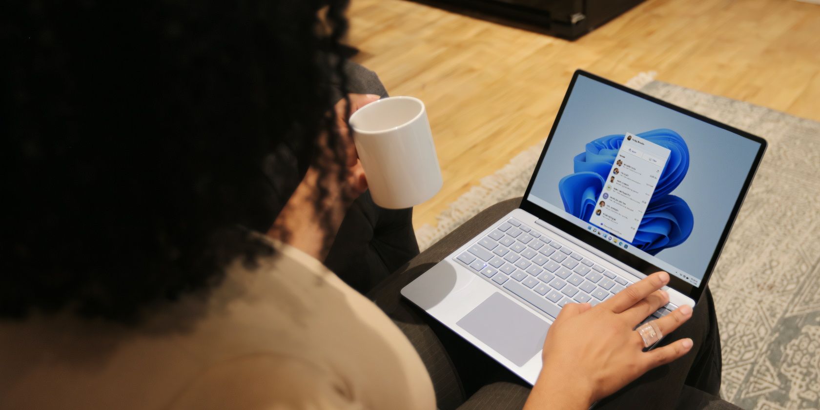 A lady using her Windows PC while holding a cup