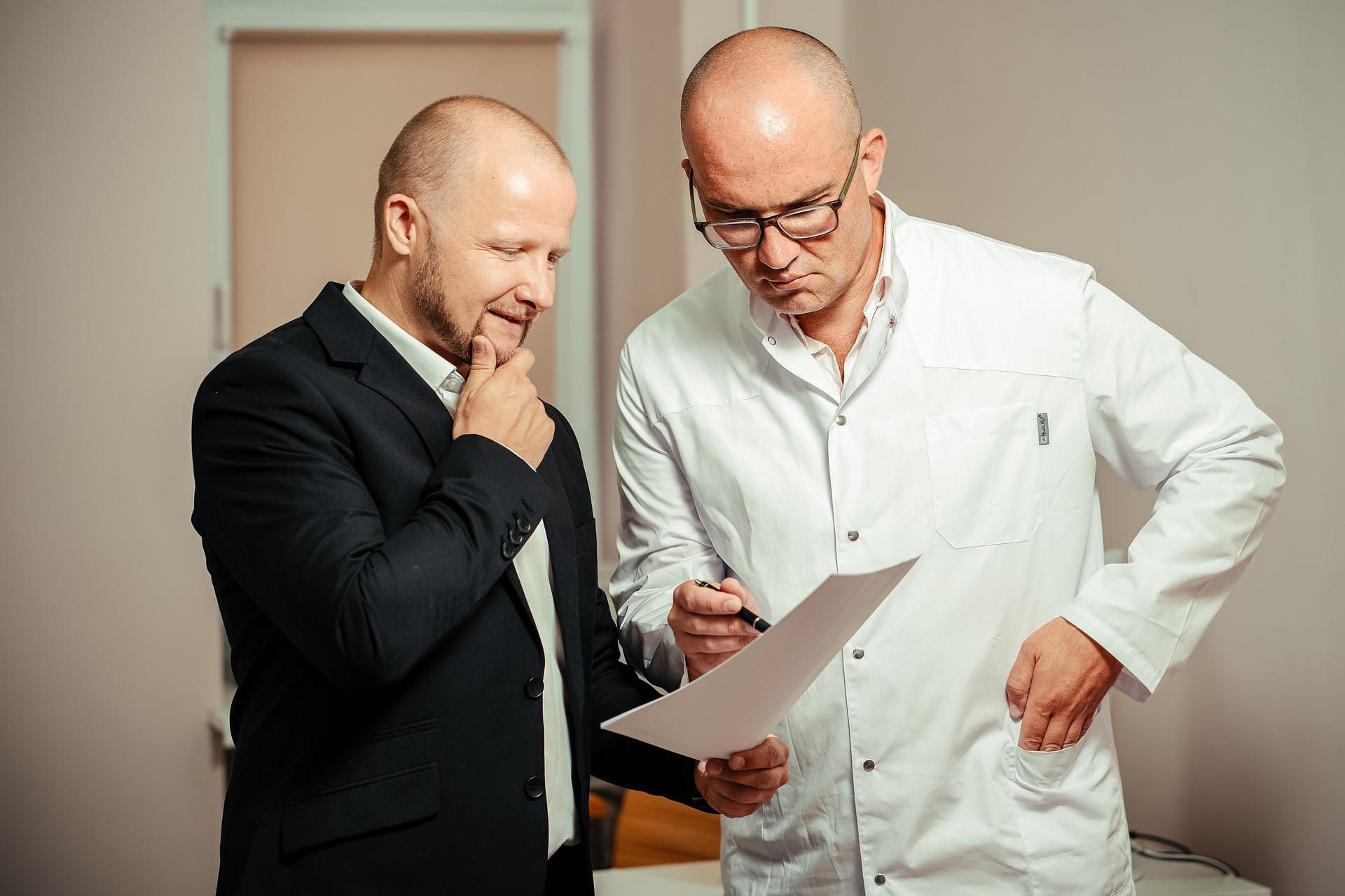 A medical specialist and a man looking at a document 