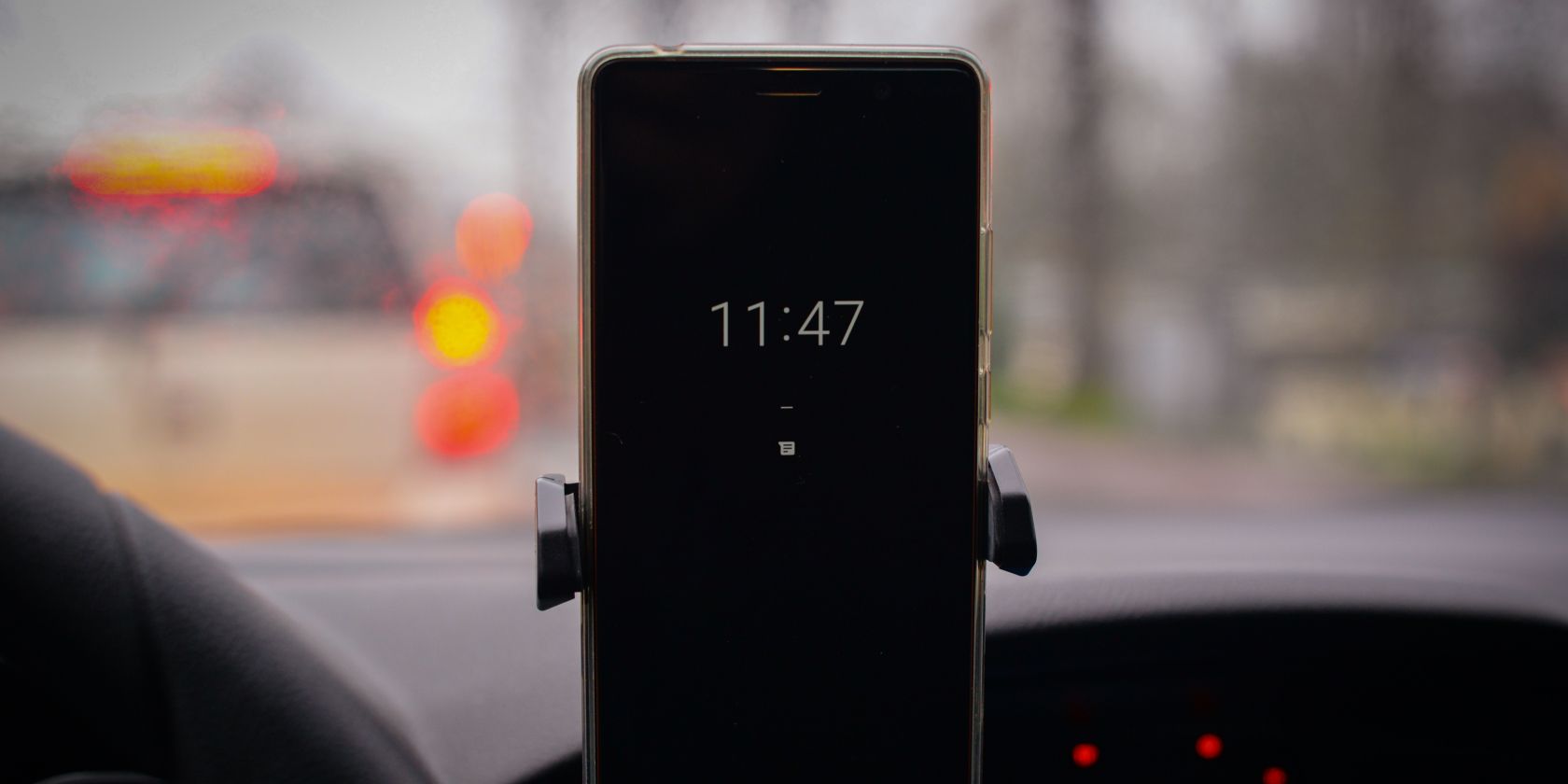 Phone in car mount displaying current time