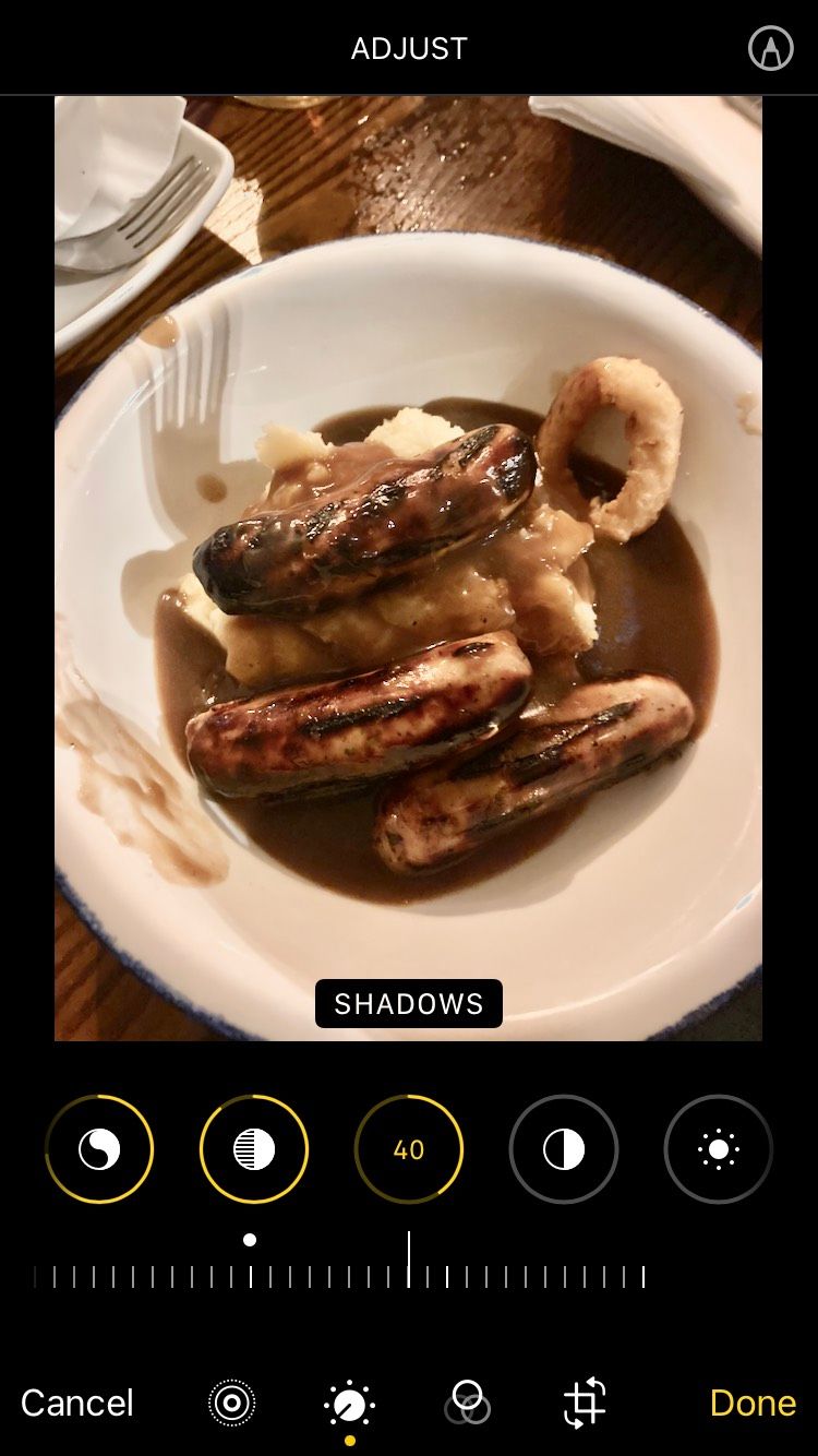 An image of sausage and mash on the iOS Apple Photos app with filters applied