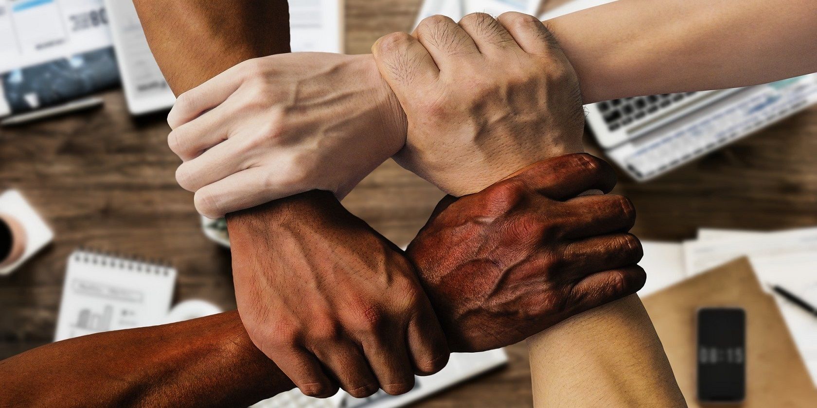 Image of four team members holding each other's wrists