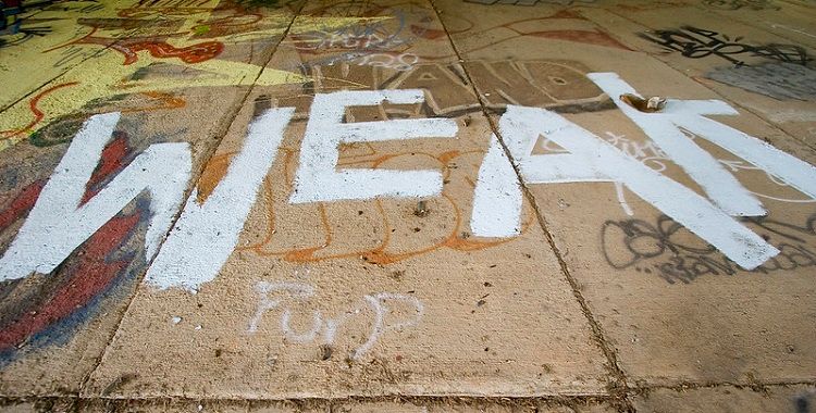 Image of the word weak spaypainted on pavement