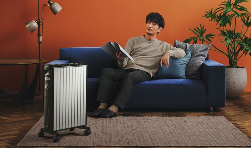 Man sitting on sofa with a smart heater next to him