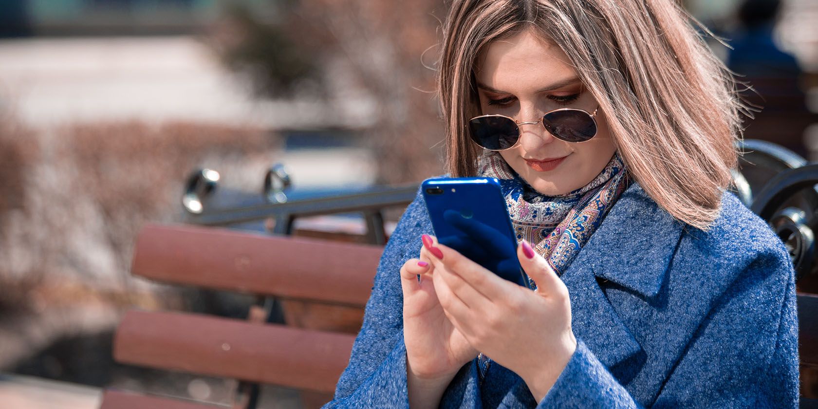 Person with sunglasses looking at smartphone
