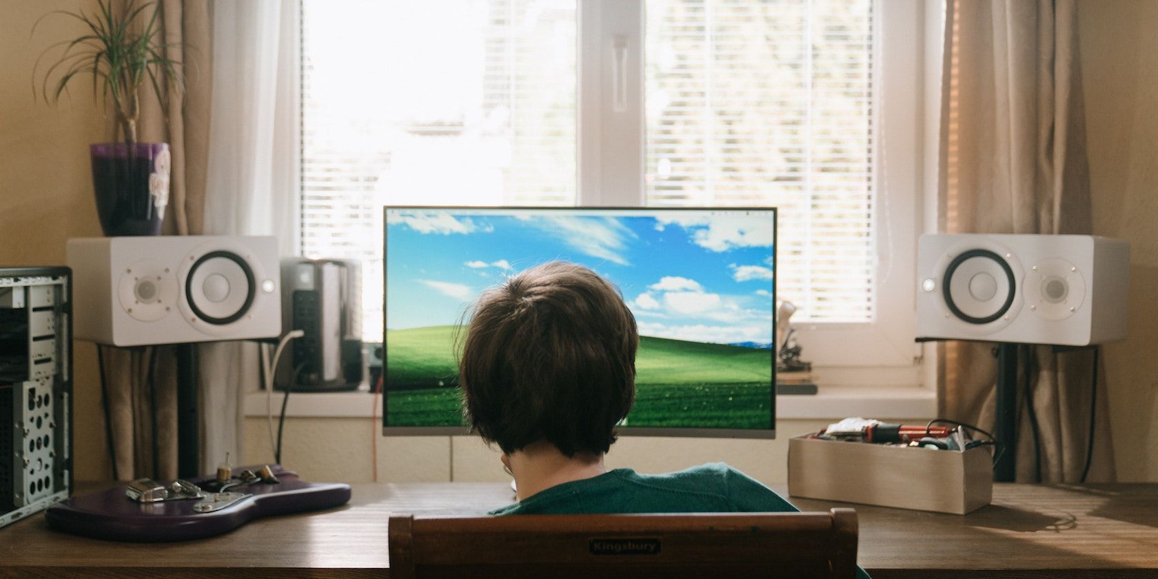 Boy in Red Shirt Sitting on Chair in Front of Computer Screen