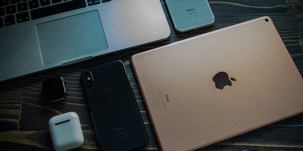 Apple MacBook, iPad, iPhones, Apple Watch and AirPods placed side-by-side