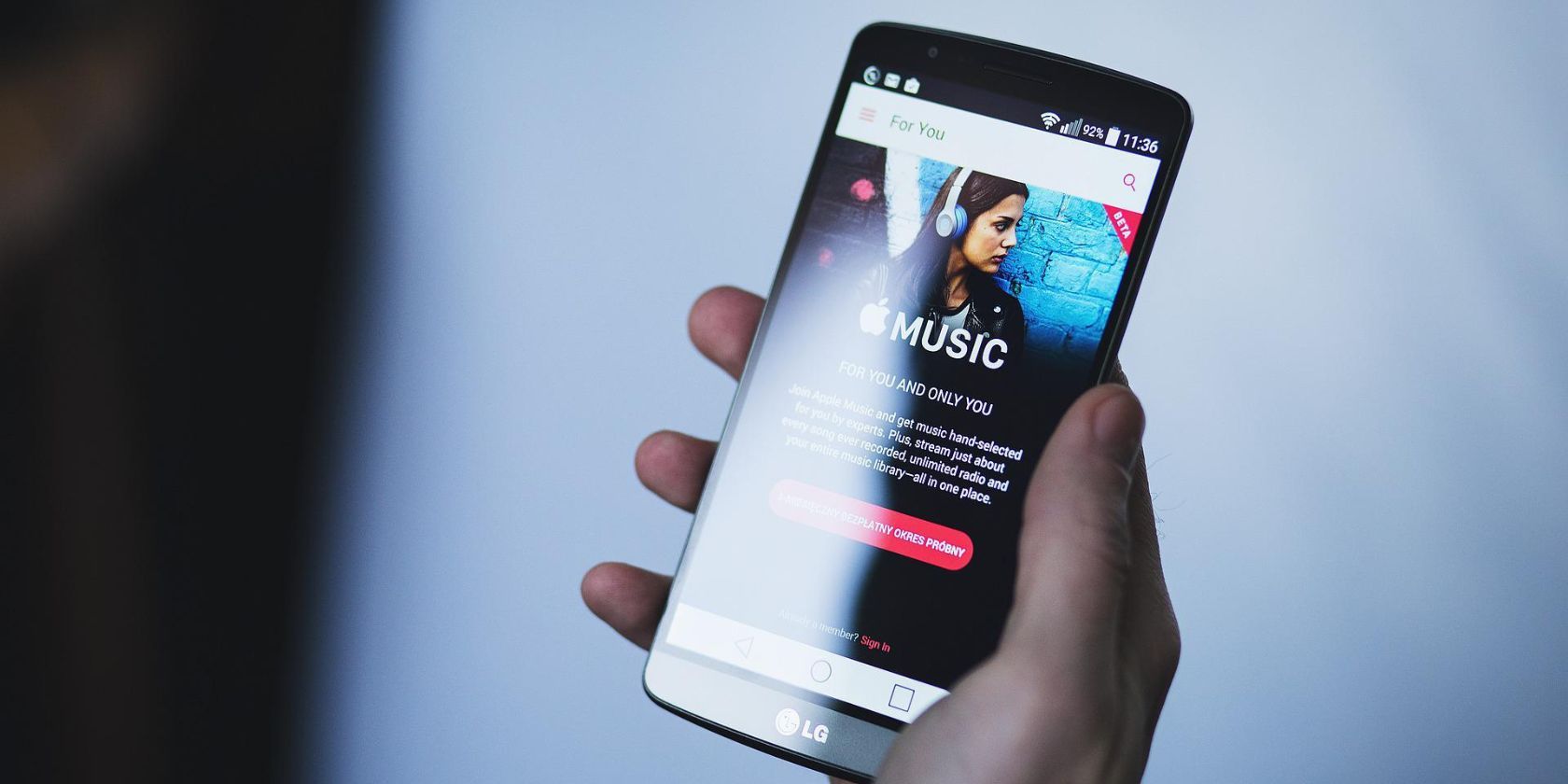 A person holding a phone with the Apple Music app on the screen