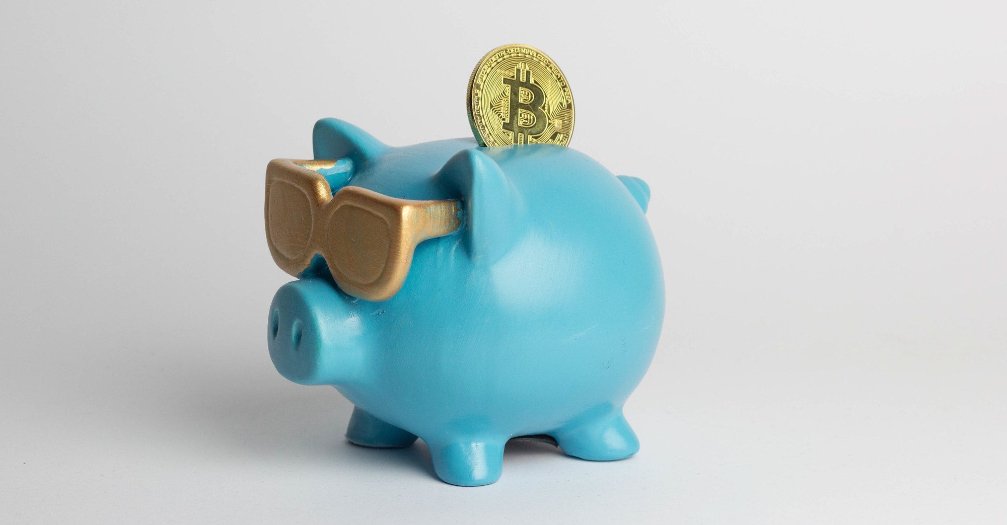 bitcoin being put into blue piggy bank