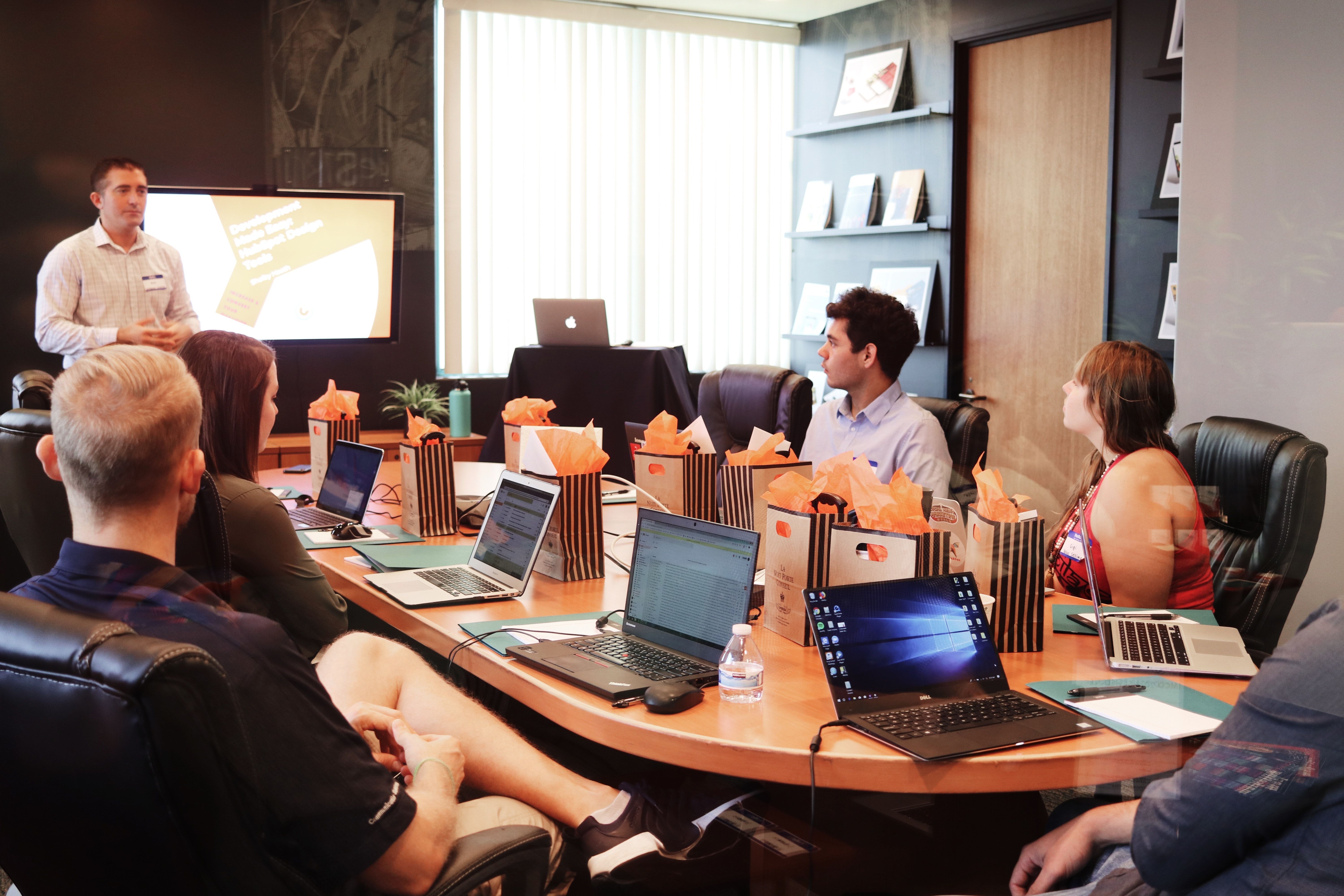 People sitting around a table listening to a business presentation