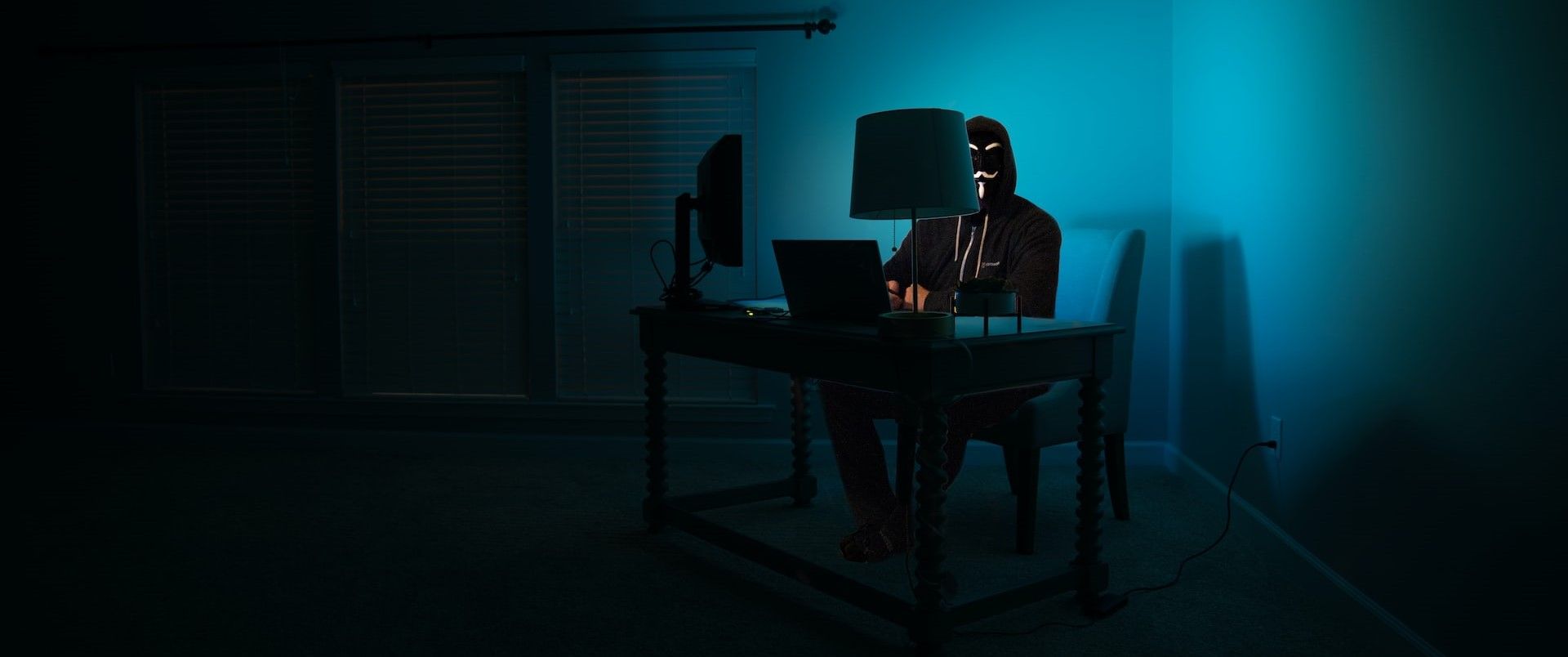 Photo of a hacker sitting at a desk