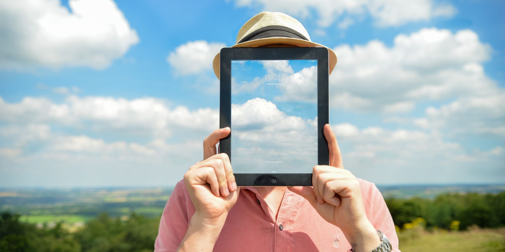 Man holding tablet with clouds image