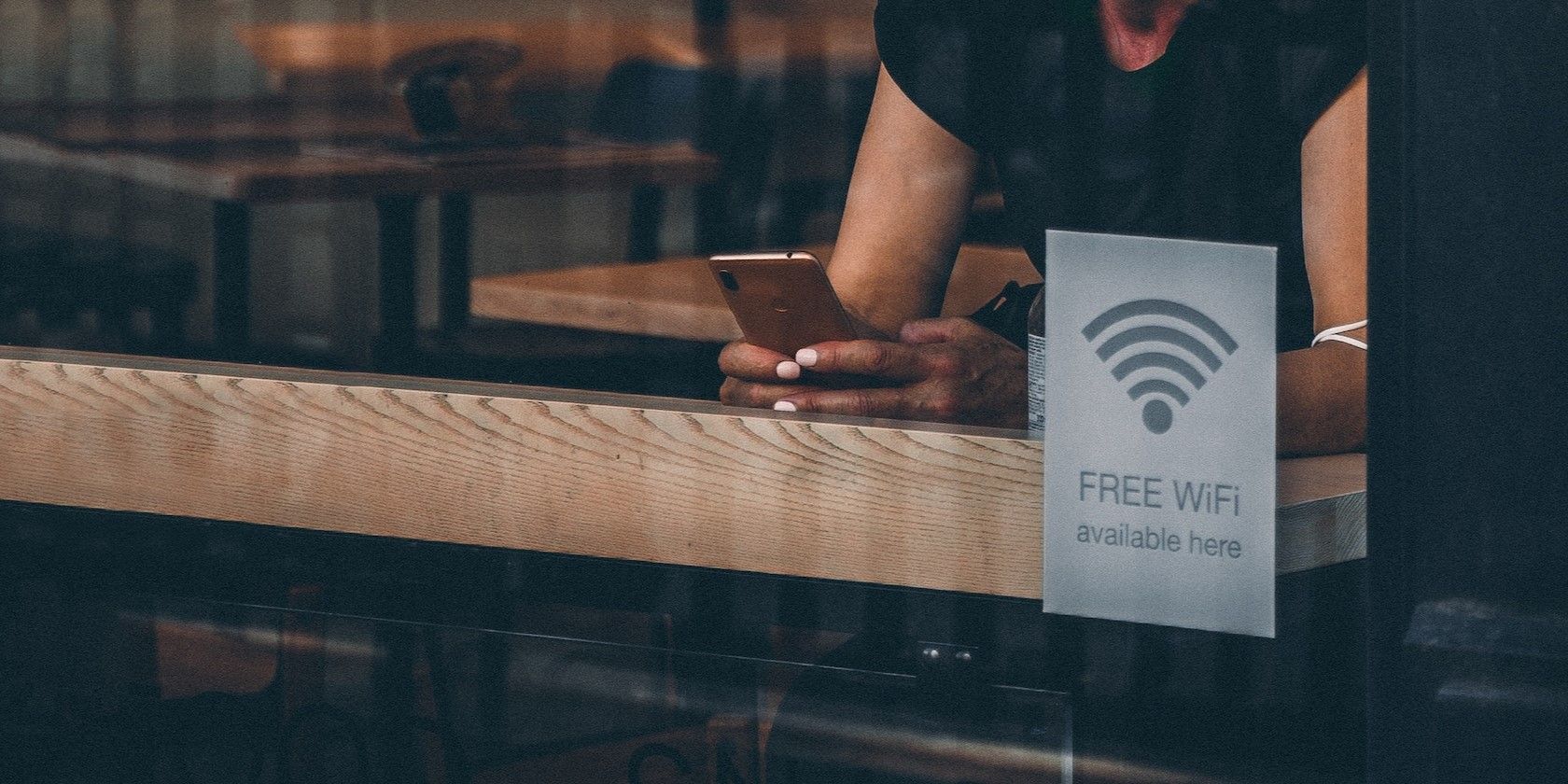 Woman in Black Tank Top Using WiFi in Coffee Shop