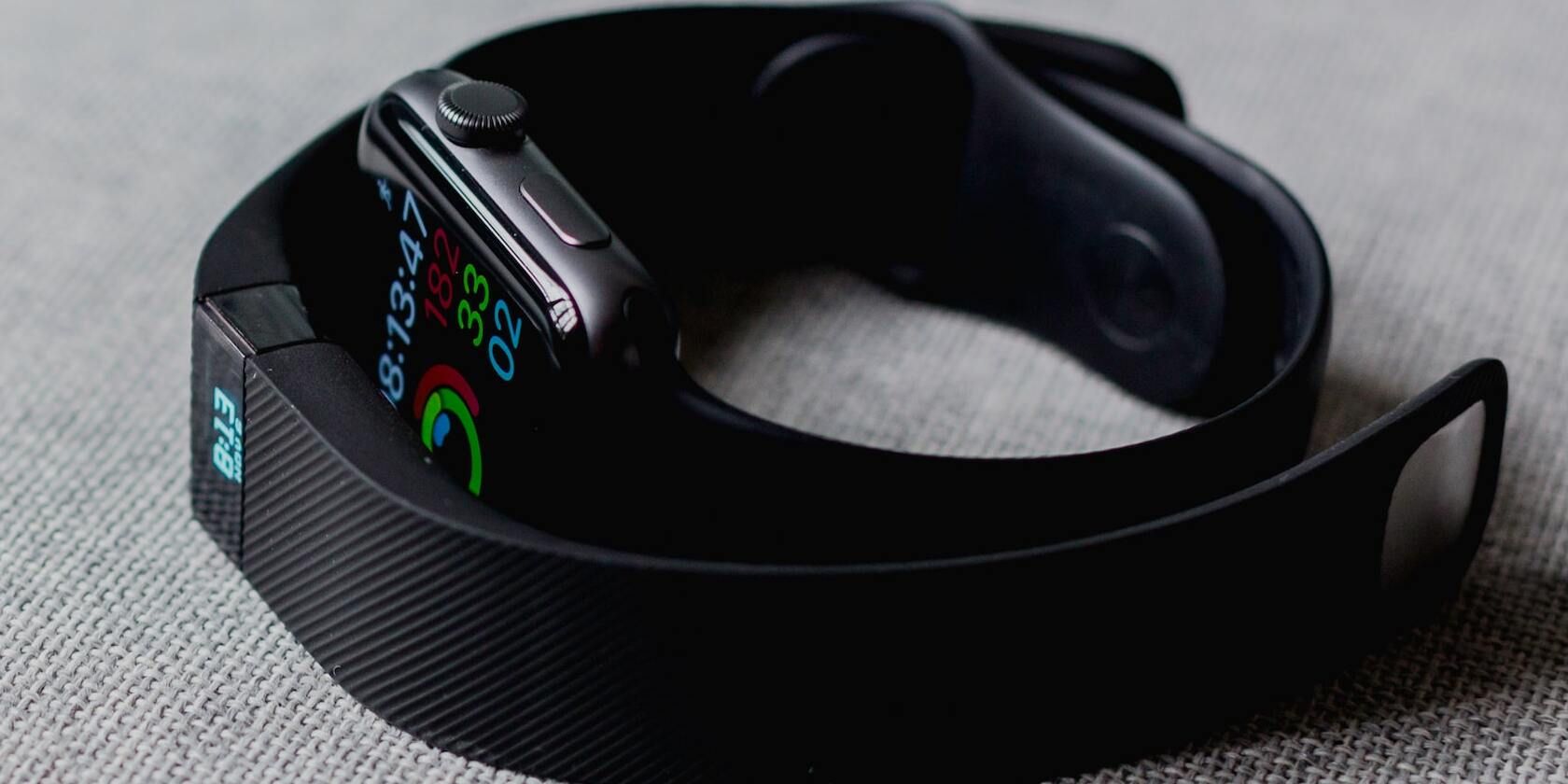 image of a Fitbit surrounding an Apple Watch