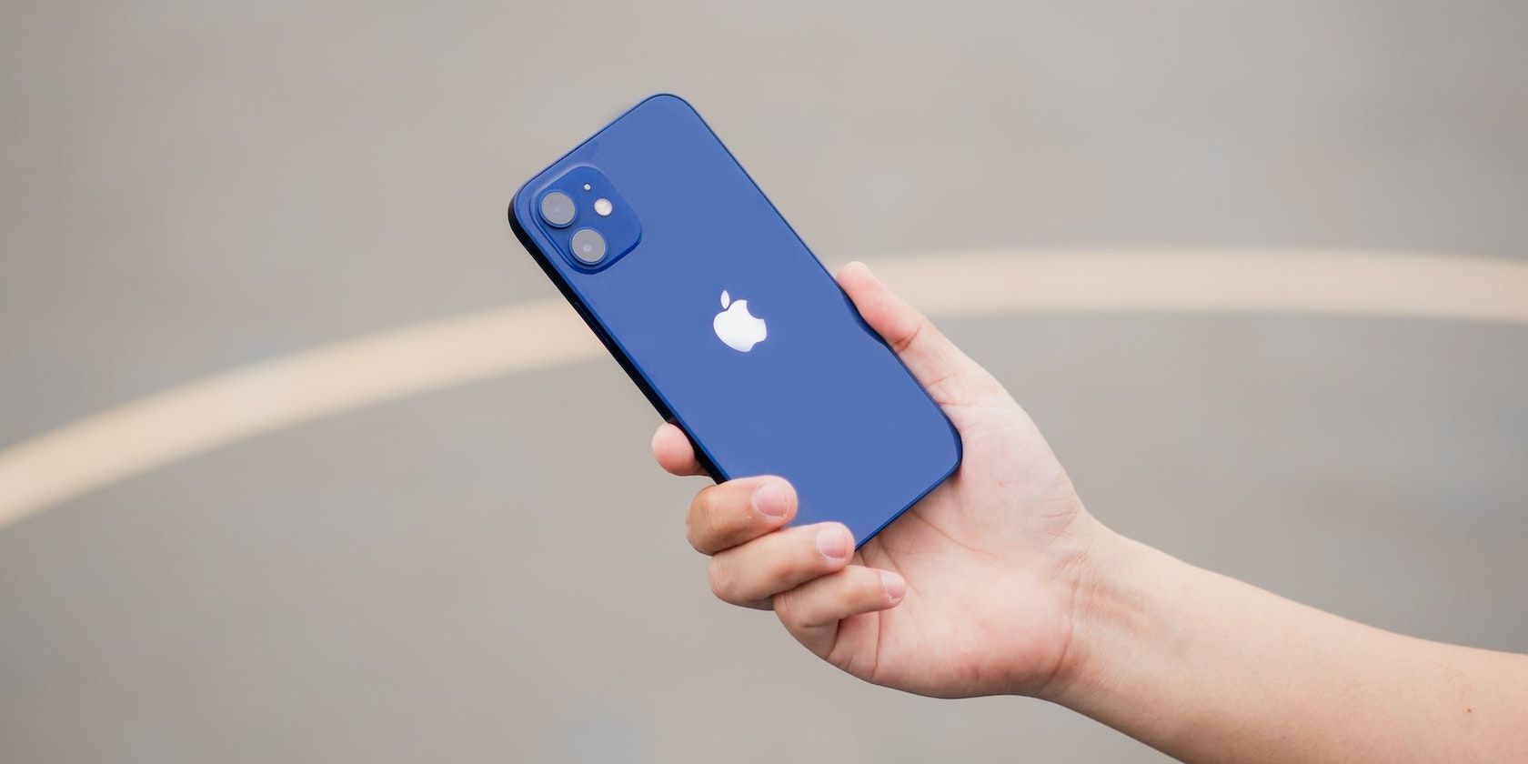 A hand holding a blue iPhone/