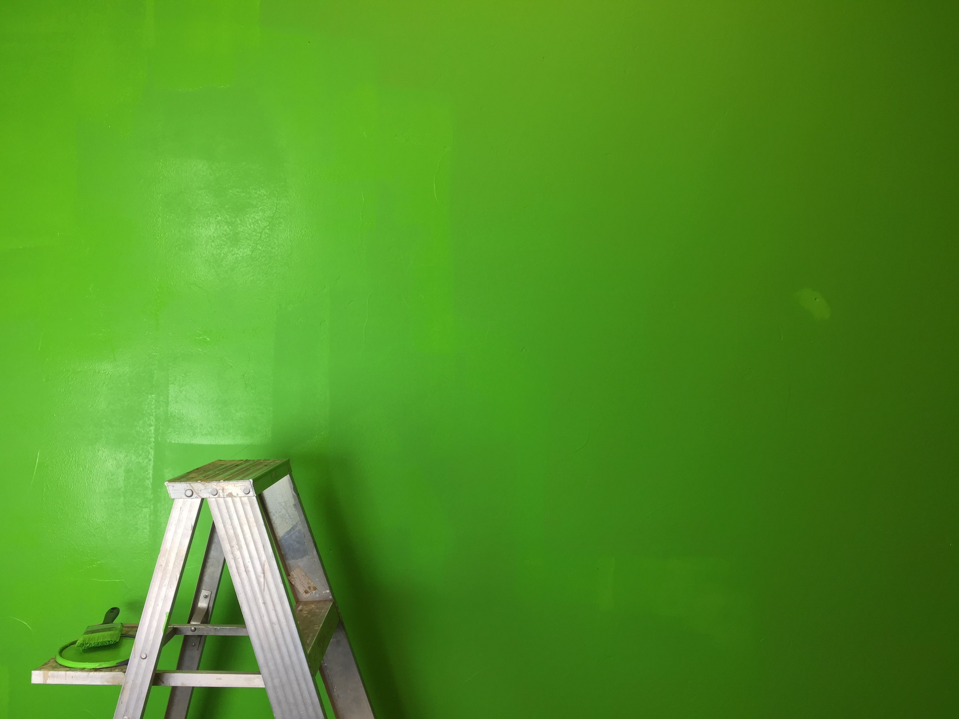 Ladder by painted green screen wall