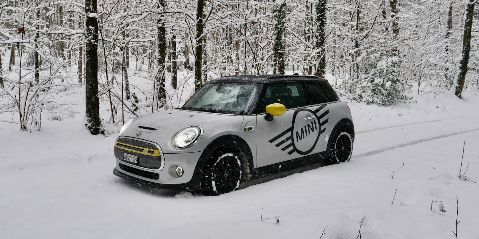 silver all electric mini cooper se in snowy forest