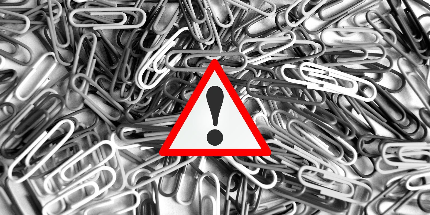 pile of paperclips behind alert symbol