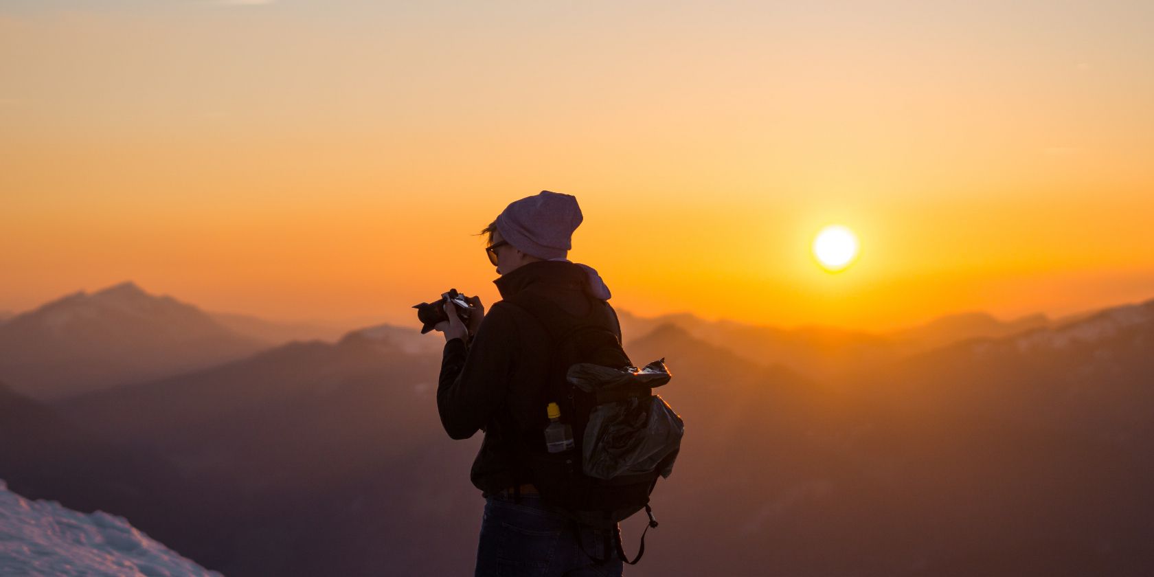 photo of someone taking photos in a mountain range
