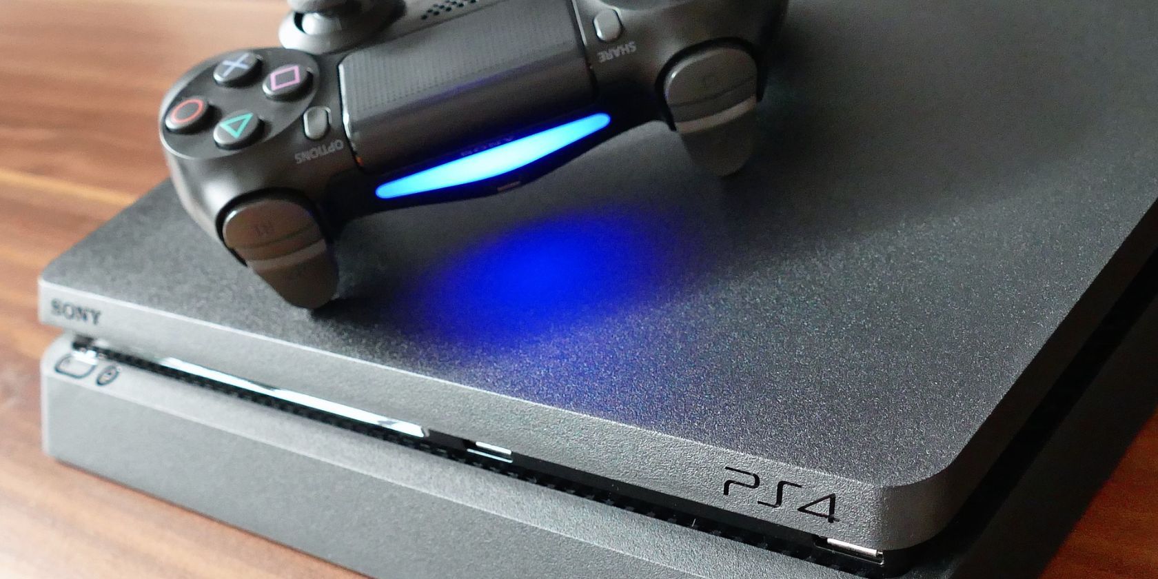 A PS4 controller on top of a PS4 console
