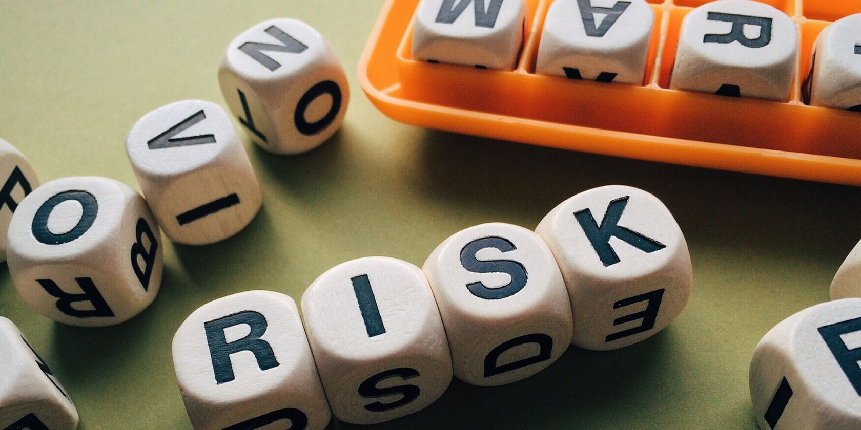 Dies with leters on them spelling out the word Risk