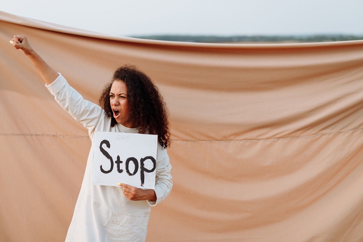 woman holding sign saying stop