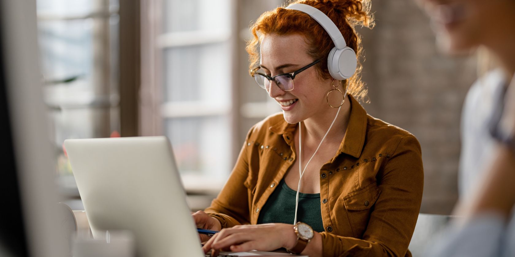 woman wearing headphones while using laptop