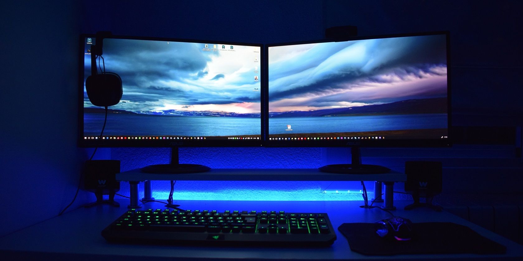 two monitors on a desk, side by side, with a keyboard and mouse
