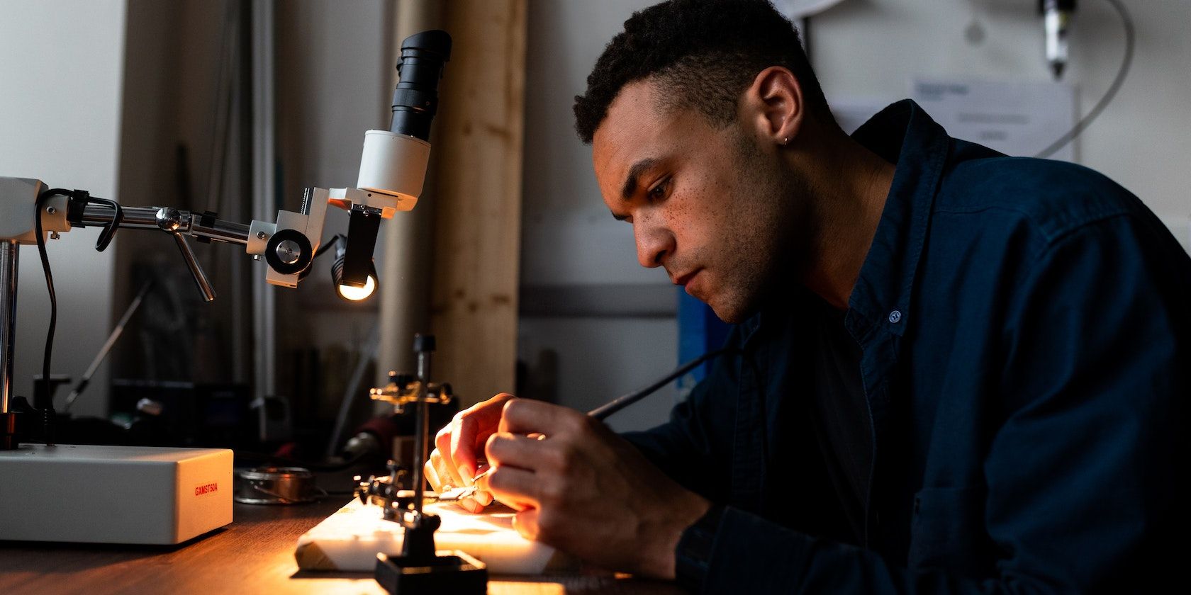 A man soldering a machine in a workshop