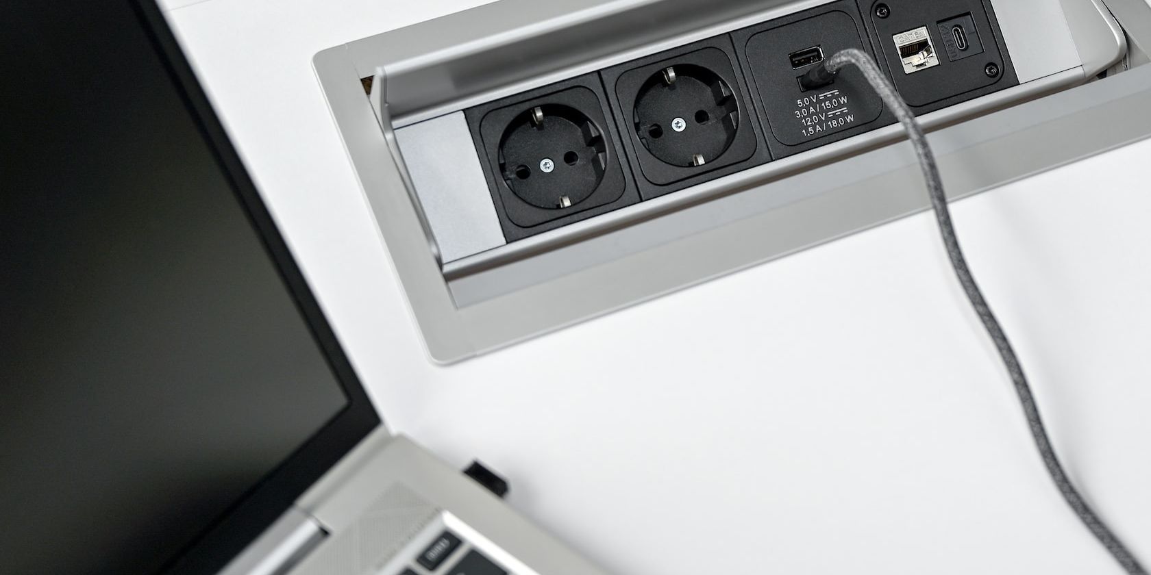 Built-in socket with usb c charger placed closed to a laptop