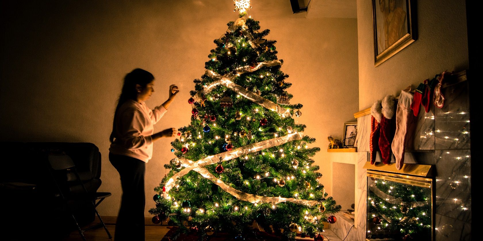 A lady beside a Christmas tree with LED lights