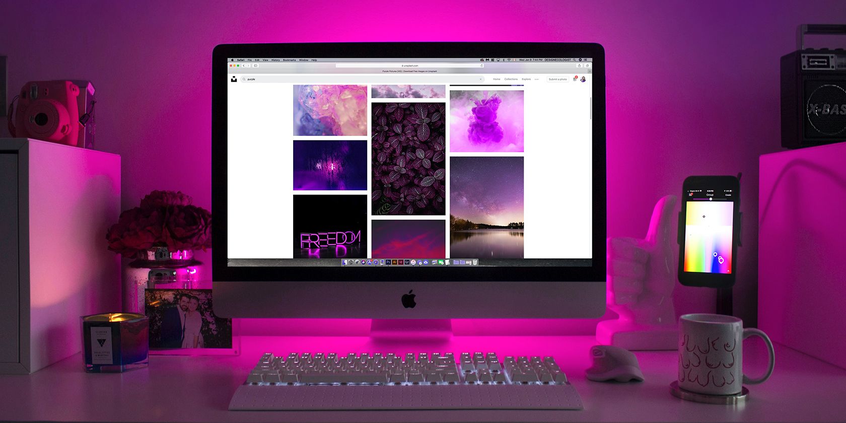 MacBook computer with Unsplash website on screen, lit in pink hue.