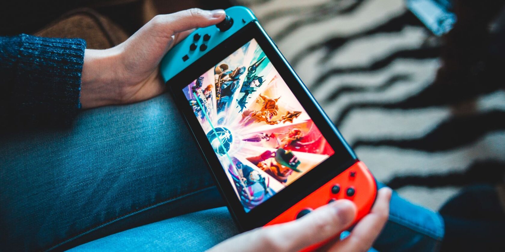 A person playing their Nintendo Switch in handheld mode