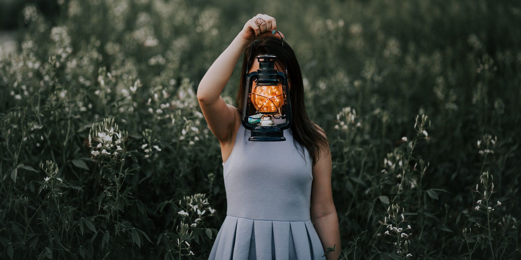 A lady holding a lantern with fireflies